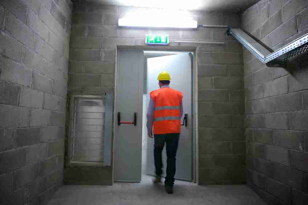 construction worker using a fire emergency exit during a risk of flames and smoke using the on site plan created by officials