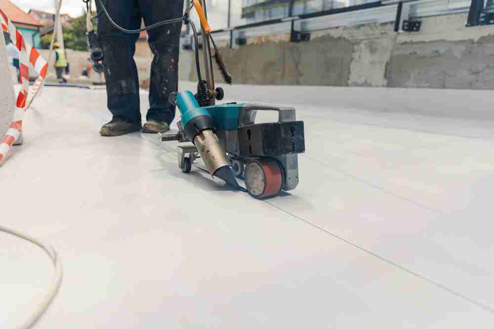 welding pvc on a rooftop during roof construction using safety tools and equipment