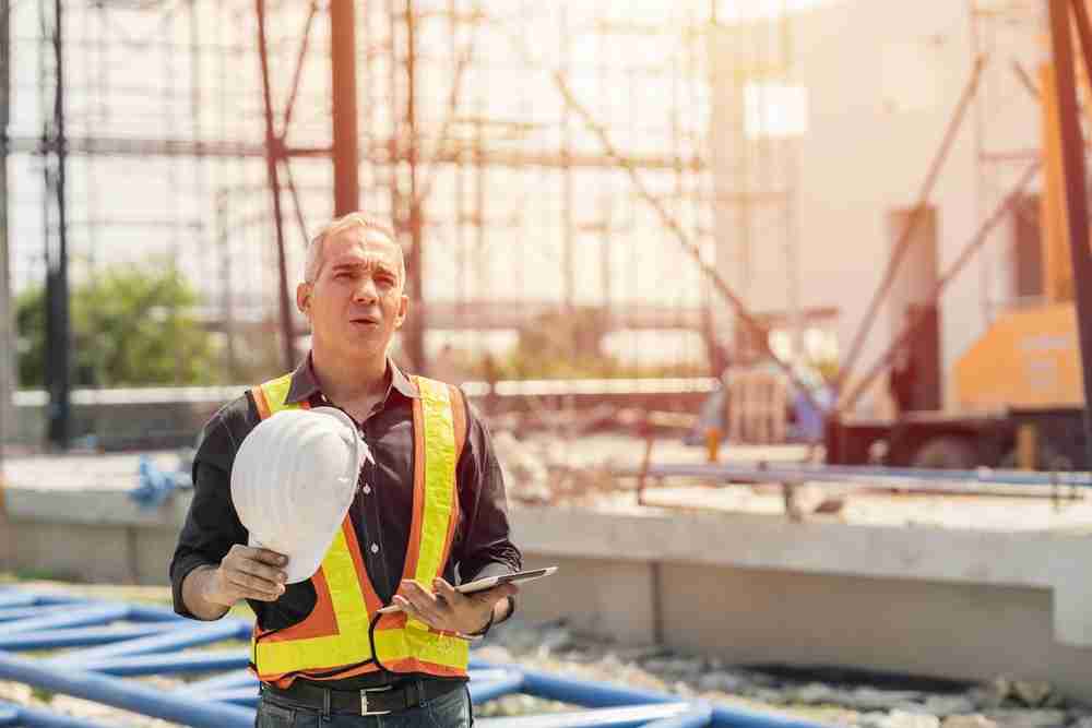 construction worker dehydrated and hot in extreme heat conditions during summer construction site project