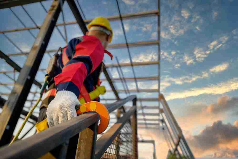 construction worker using fall arrest kit safety harness for theme park maintenance