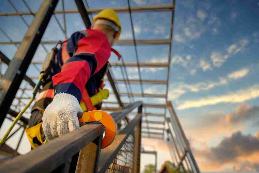 construction worker wearing fall protection equipment harness lanyard to prevent slips trips and falls